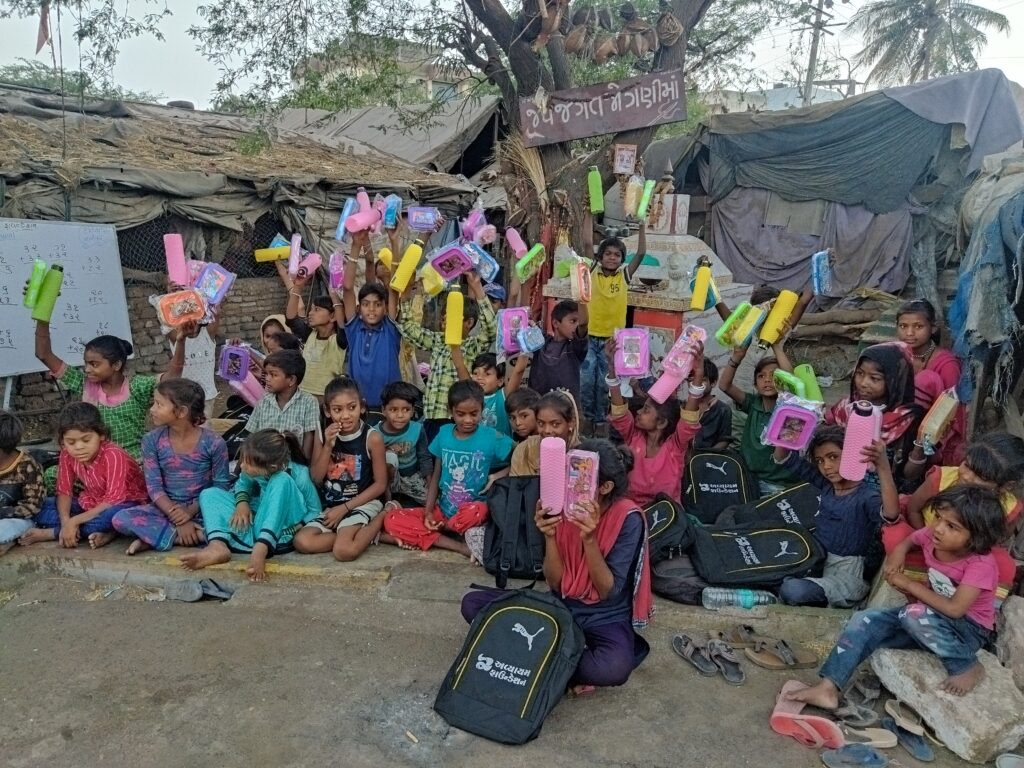The children are joyfully holding up their new school supplies and lunch kits provided by the Avyaym Foundation Trust. This moment captures our ongoing mission to support education and nutritional well-being for every child in our community